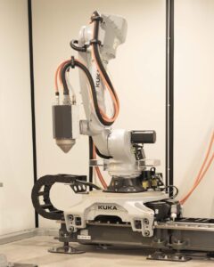 Le robot Kuka armé de sa tête d’impression Meltio est monté sur un rail.